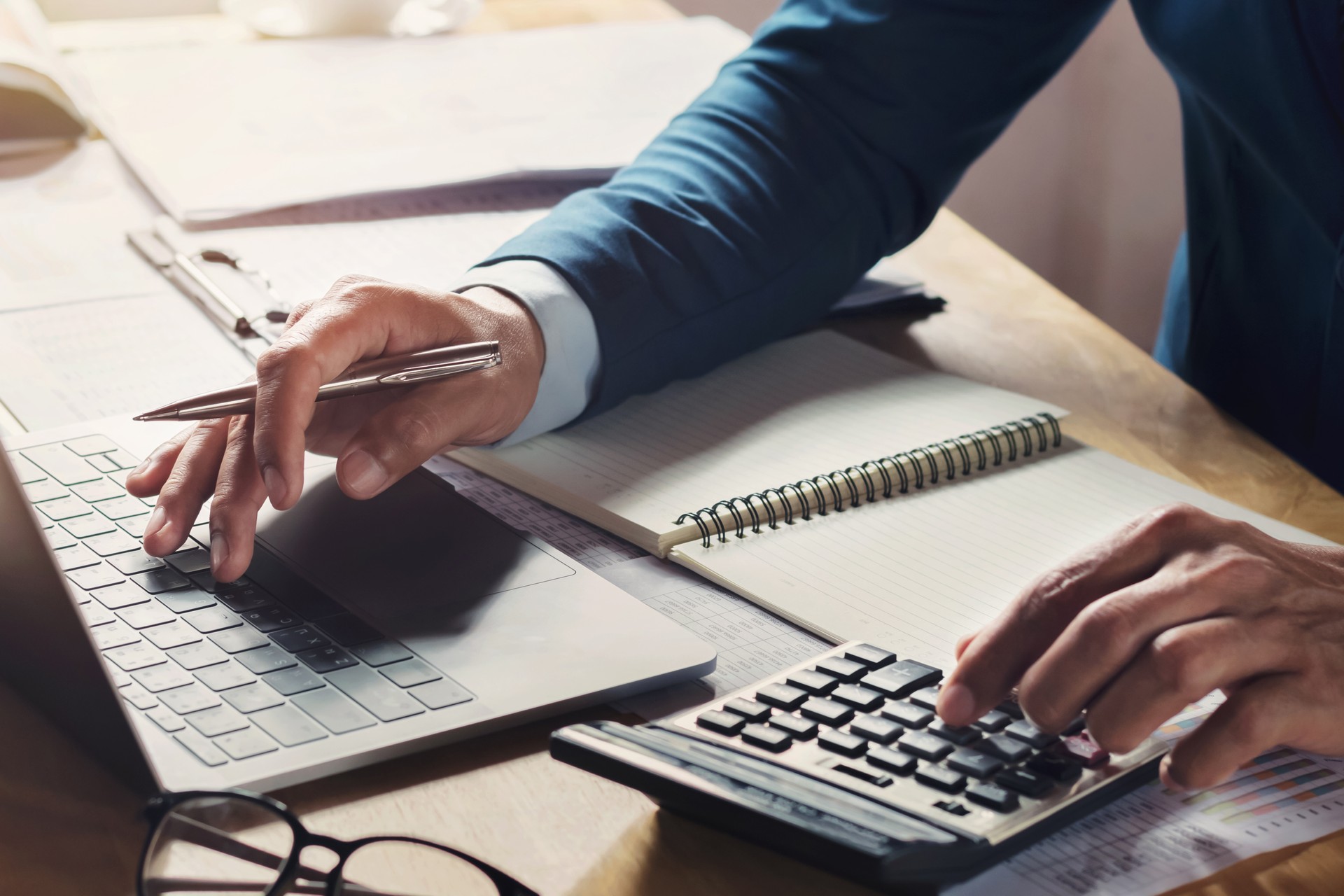 businessman workig and using calculator with laptop on desk